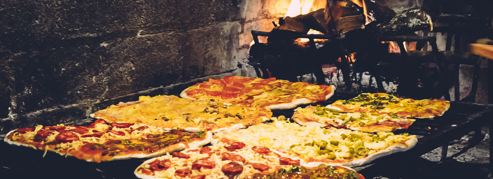 Pizzas a la parrilla cocinándose en un evento.